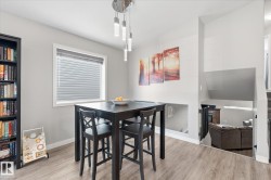Laminate wood-finish flooring, recessed lower level, and a modern chandelier with pendant lights - 