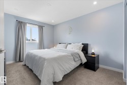 Recessed ceiling lighting, light blue wall finishes, and a window with a dark-finish curtain rod - 