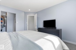 Recessed ceiling lighting, light blue wall finishes, carpeted flooring, and a built-in closet with sliding doors - 