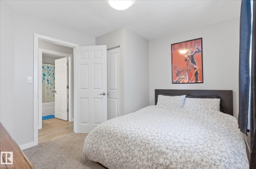 Carpeted flooring, light grey wall paint, six-panel interior doors, light wood-finish flooring, and an overhead light fixture - 2109 37 Avenue Nw, Edmonton, AB 