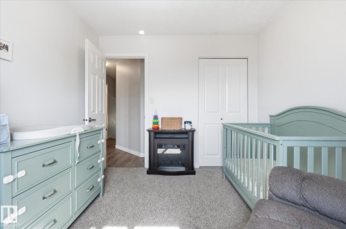 Carpeted room with white walls, a white paneled door, and a built-in bi-fold closet - 2109 37 Avenue Nw, Edmonton, AB 