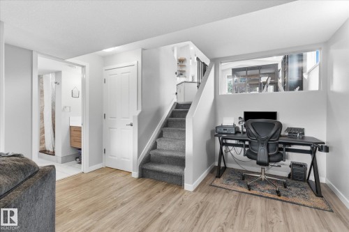 Wood-finish flooring, carpeted staircase, white interior doors, recessed lighting, and a transom window - 2109 37 Avenue Nw, Edmonton, AB 