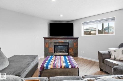 Fireplace with a stone surround and wood mantel - 2109 37 Avenue Nw, Edmonton, AB 