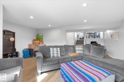 Recessed ceiling lighting, wood-finish flooring, light gray wall paint, and white trim - 