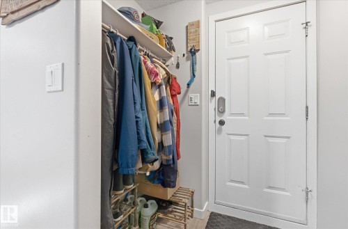 Panel entry door with a digital lock and a built-in closet with shelving and hanging rod - 2109 37 Avenue Nw, Edmonton, AB 