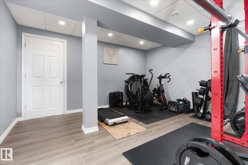 Recessed lighting, wood-finish flooring, light gray wall paint, white trim, and a paneled interior door - 2109 37 Avenue Nw, Edmonton, AB 