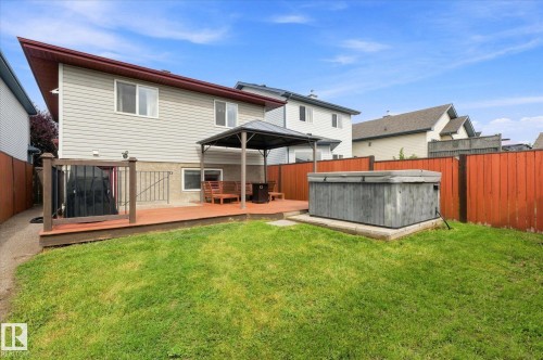 Expansive backyard featuring a wood deck, built-in hot tub, and privacy fencing - 2109 37 Avenue Nw, Edmonton, AB 