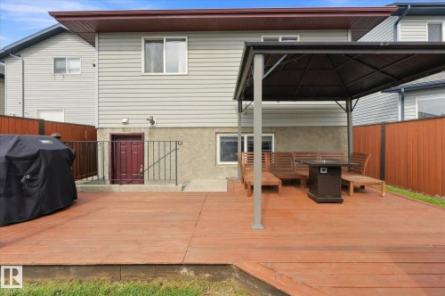 Expansive wood deck with a built-in gazebo frame, concrete patio, and a privacy fence - 2109 37 Avenue Nw, Edmonton, AB 