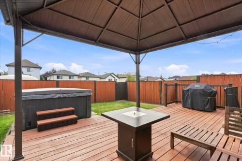 Expansive backyard featuring a wood-finish deck, covered gazebo, privacy fencing, and hot tub - 2109 37 Avenue Nw, Edmonton, AB 