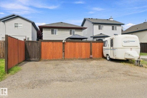 Gravel parking area featuring a wooden privacy fence with a gate - 2109 37 Avenue Nw, Edmonton, AB 