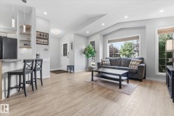 Light wood-finish flooring, recessed lighting, built-in shelving, and large windows - 
