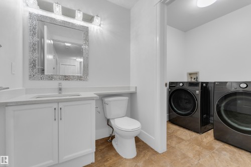 White vanity with dual cabinet doors, integrated sink, and chrome faucet - 3003 25 Avenue Nw, Edmonton, AB 