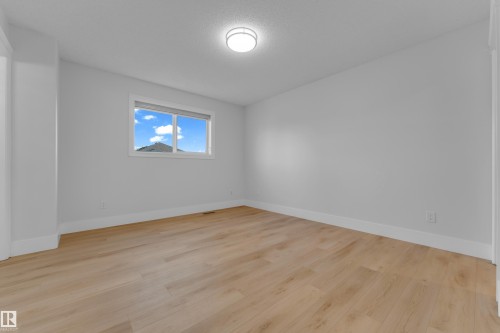 Light wood-finish flooring, white walls, recessed window, and flush mount ceiling light fixture - 3003 25 Avenue Nw, Edmonton, AB 