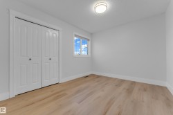 Light wood-finish flooring, white walls, and a flush mount ceiling light - 