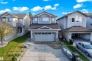 Two-story property featuring light grey siding, a front-facing attached garage, and a concrete driveway - 3003 25 Avenue Nw, Edmonton, AB 