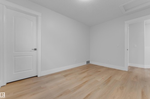 Light wood-finish flooring with crisp white walls and trim - 3003 25 Avenue Nw, Edmonton, AB 