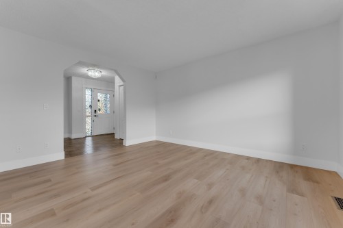 Light wood-finish flooring with white baseboards throughout - 3003 25 Avenue Nw, Edmonton, AB 