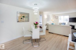 Light wood-finish flooring, recessed lighting, and a modern chandelier with circular rings - 