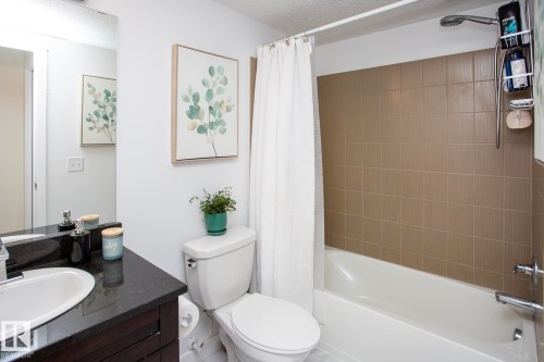 Built-in bathtub with subway tile surround, chrome fixtures, and a shower head - #201 1070 Mcconachie Bv Nw, Edmonton, AB 
