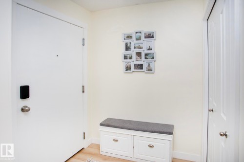 Light-toned walls, wood-finish flooring, and white doors - #201 1070 Mcconachie Bv Nw, Edmonton, AB 