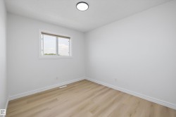 Bright interior space featuring a window with white trim, wood-finish flooring, white baseboards, and a flush-mount ceiling light fixture - 
