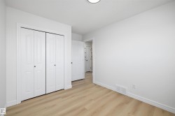 Bright interior space featuring light wood-finish flooring, white walls, and white baseboards - 