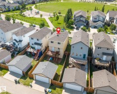 Rear elevation featuring a two-story design, attached elevated deck with stairs, a detached single-car garage, and a fenced backyard - 