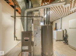 Lennox furnace, hot water heater, exposed ductwork, exposed ceiling joists, and wood-finish flooring - 