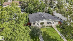 Pitched roof with dark shingles, light-colored exterior siding, and multiple front-facing windows - 
