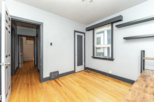 Hardwood flooring, painted walls, window with trim, built-in shelving, and white interior doors - 10930 80 Avenue Nw, Edmonton, AB 
