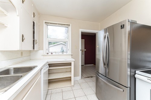 White cabinetry, stainless steel French door refrigerator, dual basin stainless steel sink, tiled flooring, and open shelving - 10930 80 Avenue Nw, Edmonton, AB 