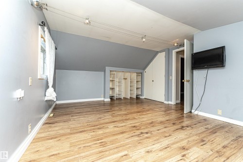 Wood-finish flooring, built-in shelving, track lighting, and a wall-mounted display - 10930 80 Avenue Nw, Edmonton, AB 
