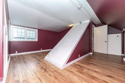 Wood-finish flooring, white trim throughout, track lighting, and a white-framed window - 10930 80 Avenue Nw, Edmonton, AB 