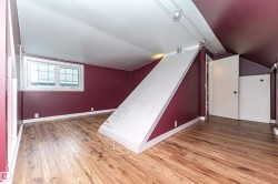 Wood-finish flooring, white trim throughout, track lighting, and a white-framed window - 