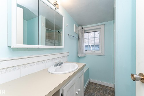 White vanity with an integrated sink and chrome faucet - 10930 80 Avenue Nw, Edmonton, AB 