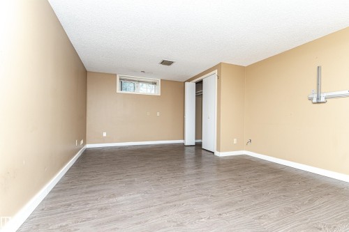 Wood-finish flooring, neutral wall tones, and a window for natural light - 10930 80 Avenue Nw, Edmonton, AB 
