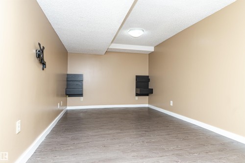 Room featuring wood-finish flooring, recessed lighting, and wall-mounted shelving units - 10930 80 Avenue Nw, Edmonton, AB 