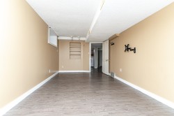 Spacious room featuring wood-finish flooring, neutral-toned walls, and recessed shelving - 