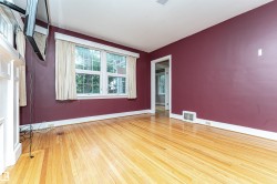 Hardwood flooring throughout, white trim, and a window with white casing - 