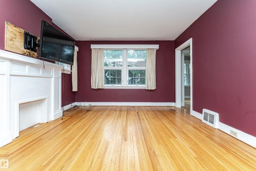 Hardwood flooring, painted interior walls, white trim, and a white mantelpiece - 10930 80 Avenue Nw, Edmonton, AB 