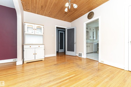 Wood-finish flooring, wood-paneled ceiling, and an arched doorway - 10930 80 Avenue Nw, Edmonton, AB 