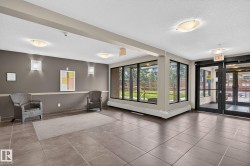 Spacious foyer featuring large format tile flooring, extensive window walls, and glass entry doors - 