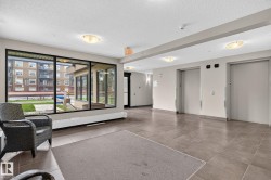 Spacious common area featuring large windows, durable tile flooring, and flush-mounted ceiling lighting - 