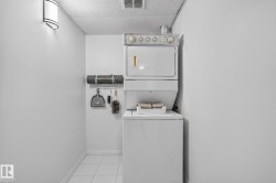 Dedicated laundry area featuring a white stackable washer and dryer unit - 