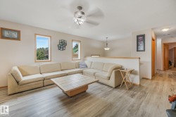 Living area featuring light wood-finish flooring and a partial wall with a wood cap - 