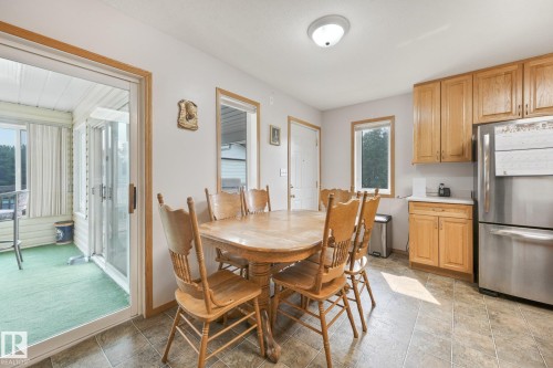 Kitchen area featuring wood-finish cabinetry, stainless steel refrigerator, and white countertops - 54 Buskmose Dr, Rural Wetaskiwin County, AB - Indoor Photo Showing Dining Room