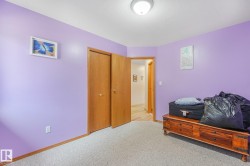 Room featuring light purple wall paint, wood-finish flooring in the hallway, and a built-in ceiling light fixture - 