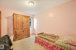 Room featuring light-colored wall paint, textured carpet flooring, and a single window - 
