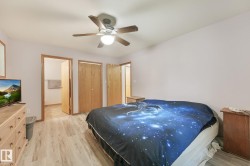 Bedroom featuring wood-finish flooring, a ceiling fan with integrated lighting, and light-toned walls - 
