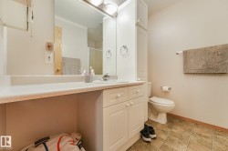 Bathroom vanity with an integrated sink, expansive countertop space, and built-in white cabinetry - 